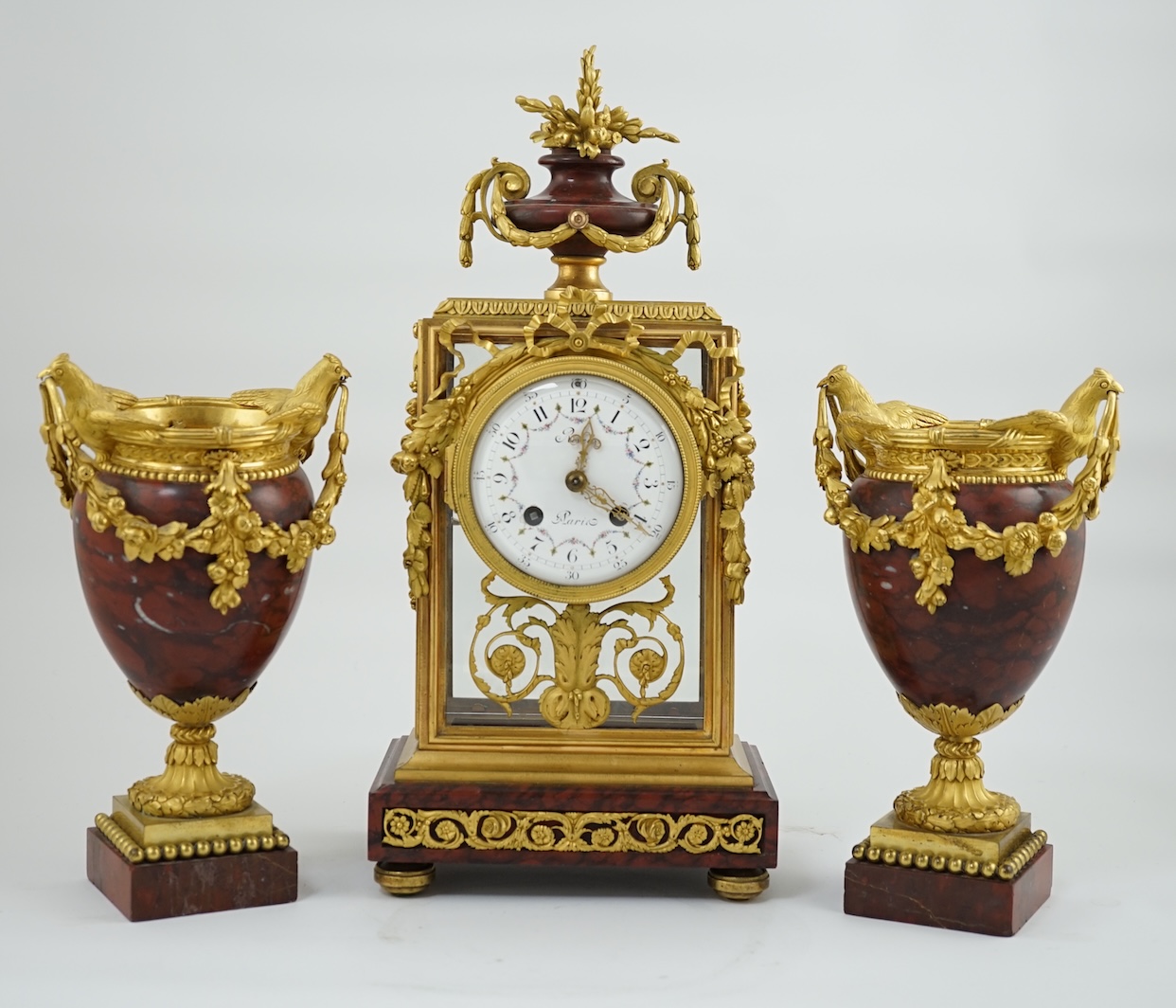 Revel à Paris. A 19th century French ormolu and rouge marble clock garniture